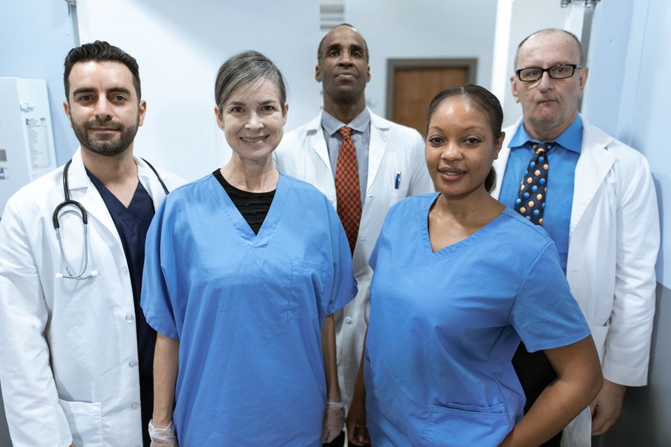 A group of nurses and clinicians standing together in a clinic corridor