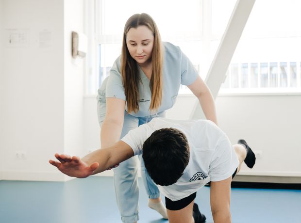 A clinician guiding a patient through a supported exercise